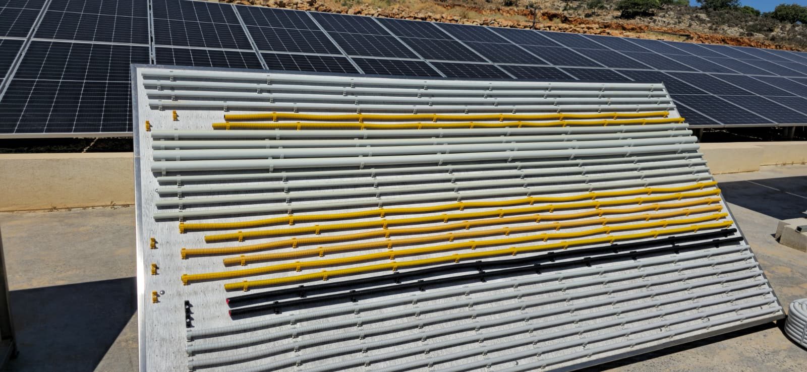 Tuburi Kouvidis pe fundalul sistemului fotovoltaic al fabricii din Creta